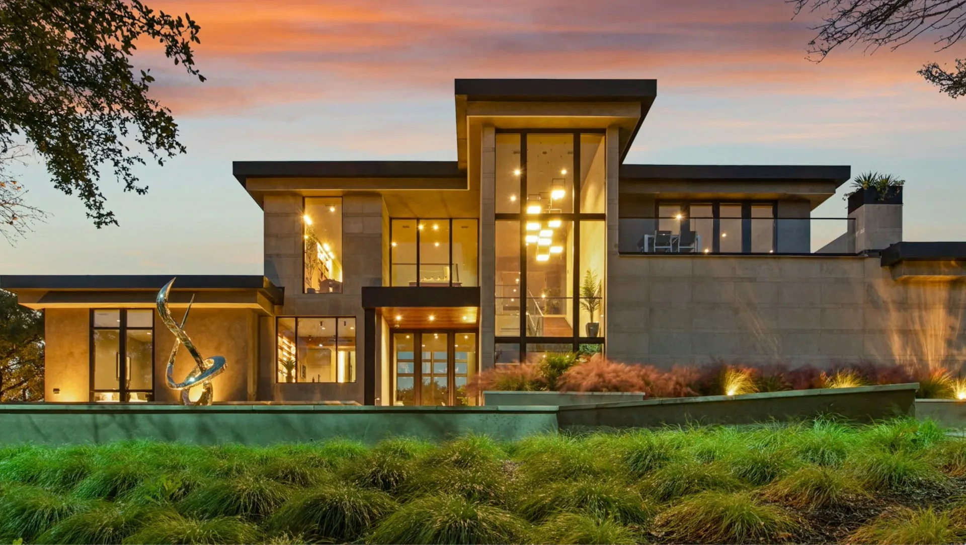 A finished modern luxury home at dusk, lit from within